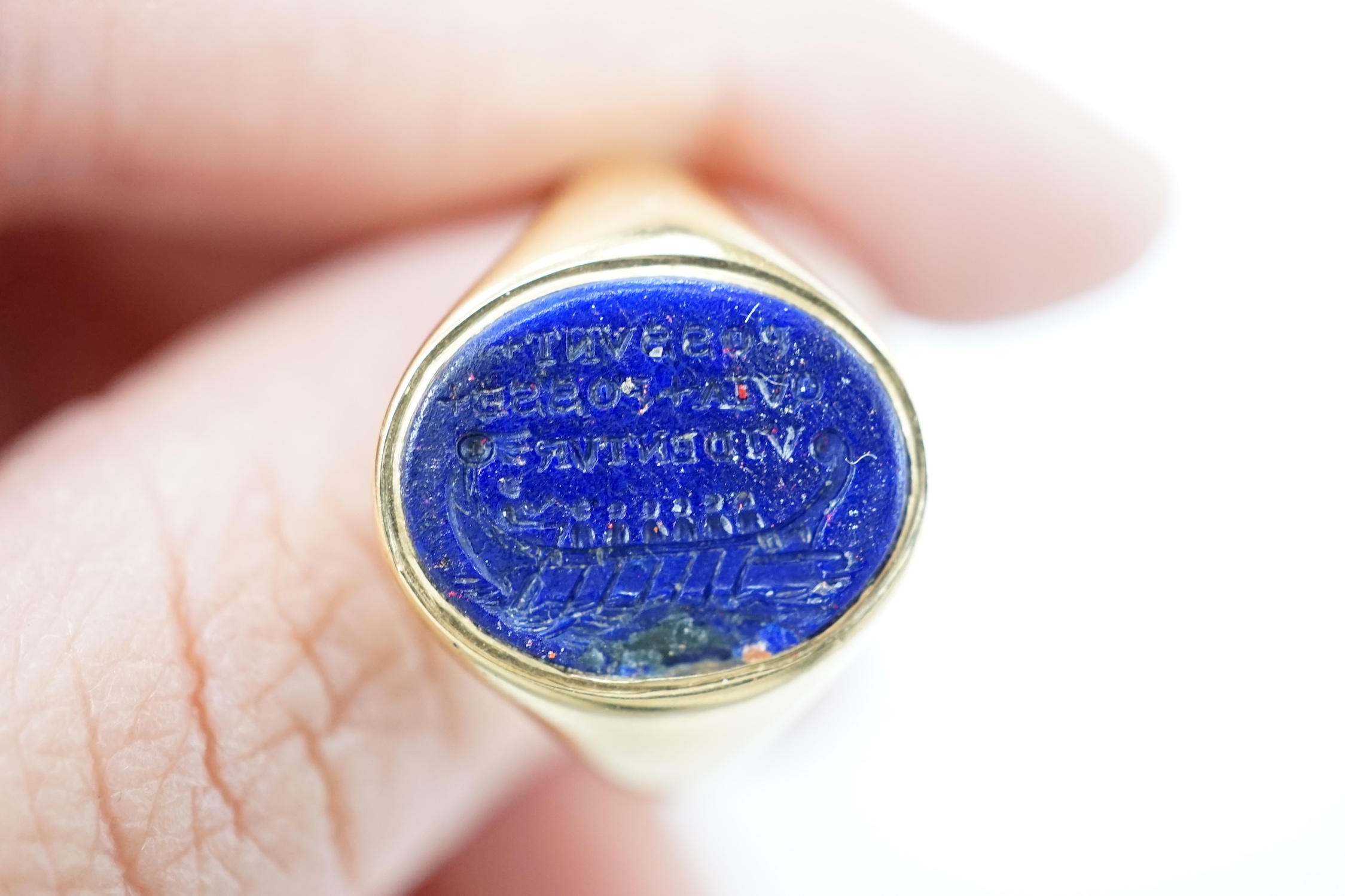 A yellow metal (stamped18) and oval intaglio lapis lazuli seal ring, carved with a longboat and the Latin motto 'Possunt, Quia Posse Videntur' (They Can Because They Think They Can), size Q, gross weight 9.9 grams.